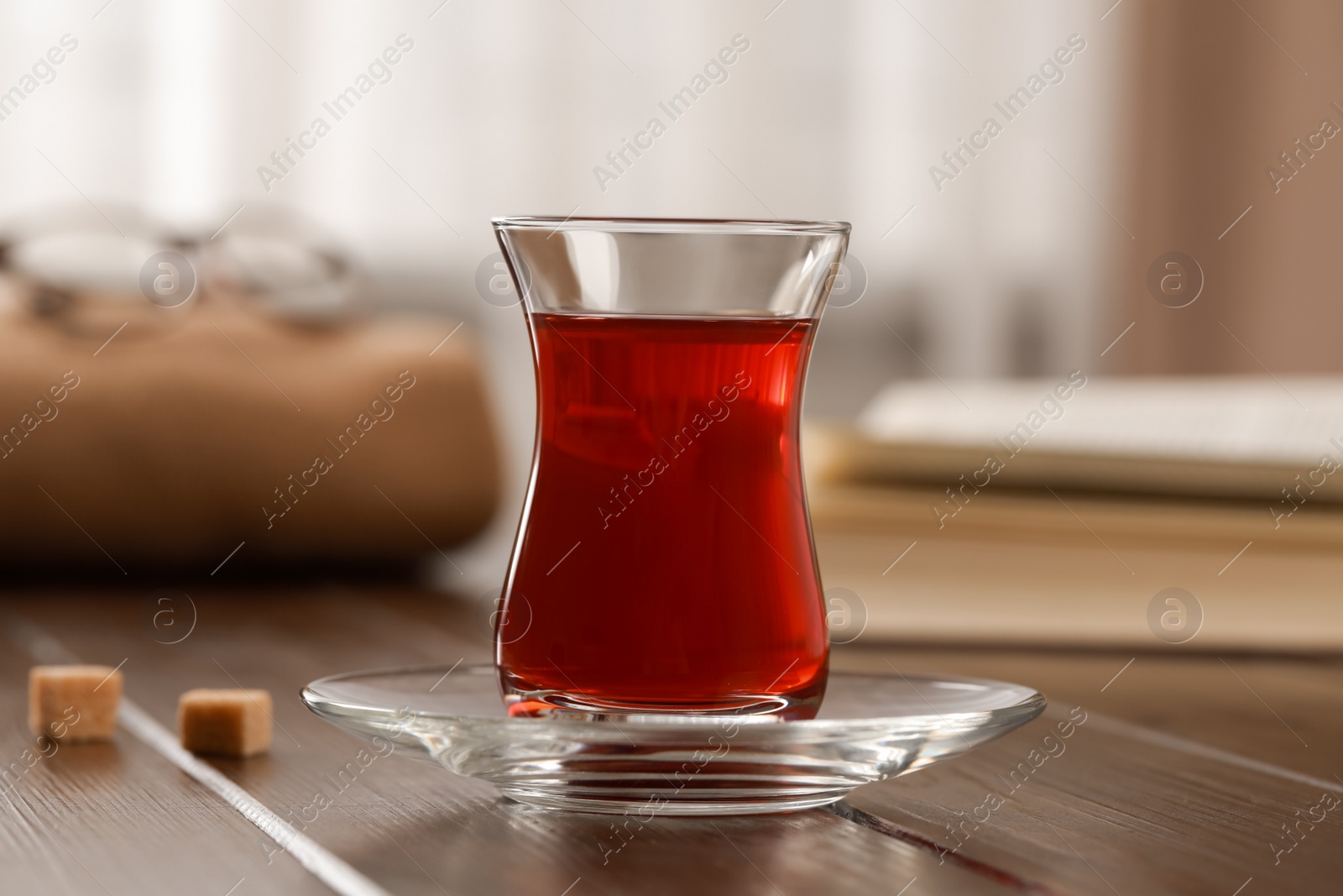 Photo of Glass of traditional Turkish tea on wooden table, closeup