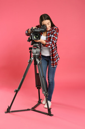 Photo of Operator with professional video camera on pink background