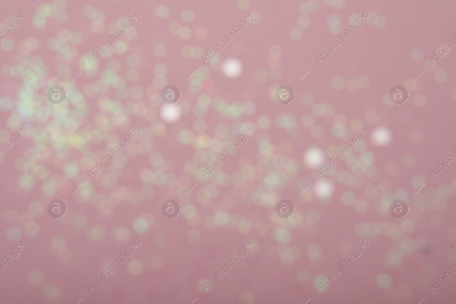 Photo of Blurred view of white glitter on pink background. Bokeh effect