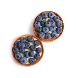 Photo of Tartlets with fresh blueberries isolated on white, top view. Delicious dessert