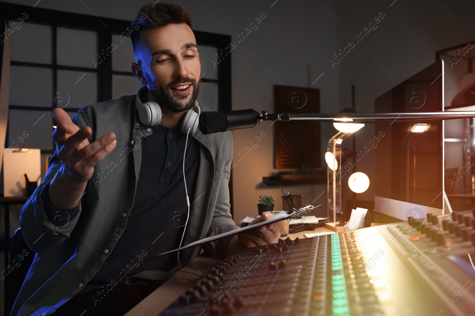 Photo of Man working as radio host in modern studio