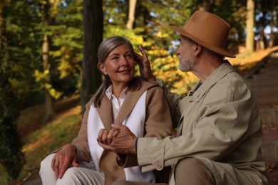 Photo of Affectionate senior couple spending time together in autumn park