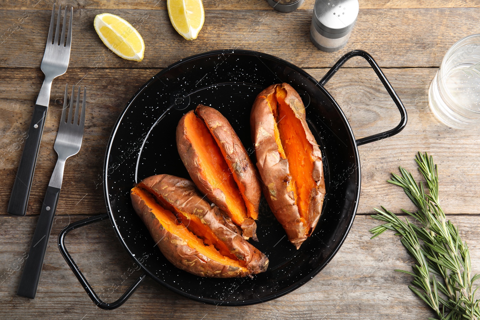 Photo of Flat lay composition with baked sweet potatoes in dish on wooden background