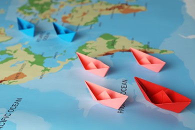 Photo of Group of colorful paper boats on world map