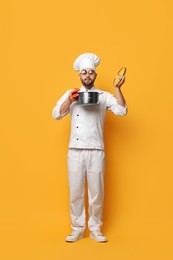 Professional chef smelling something in cooking pot on yellow background