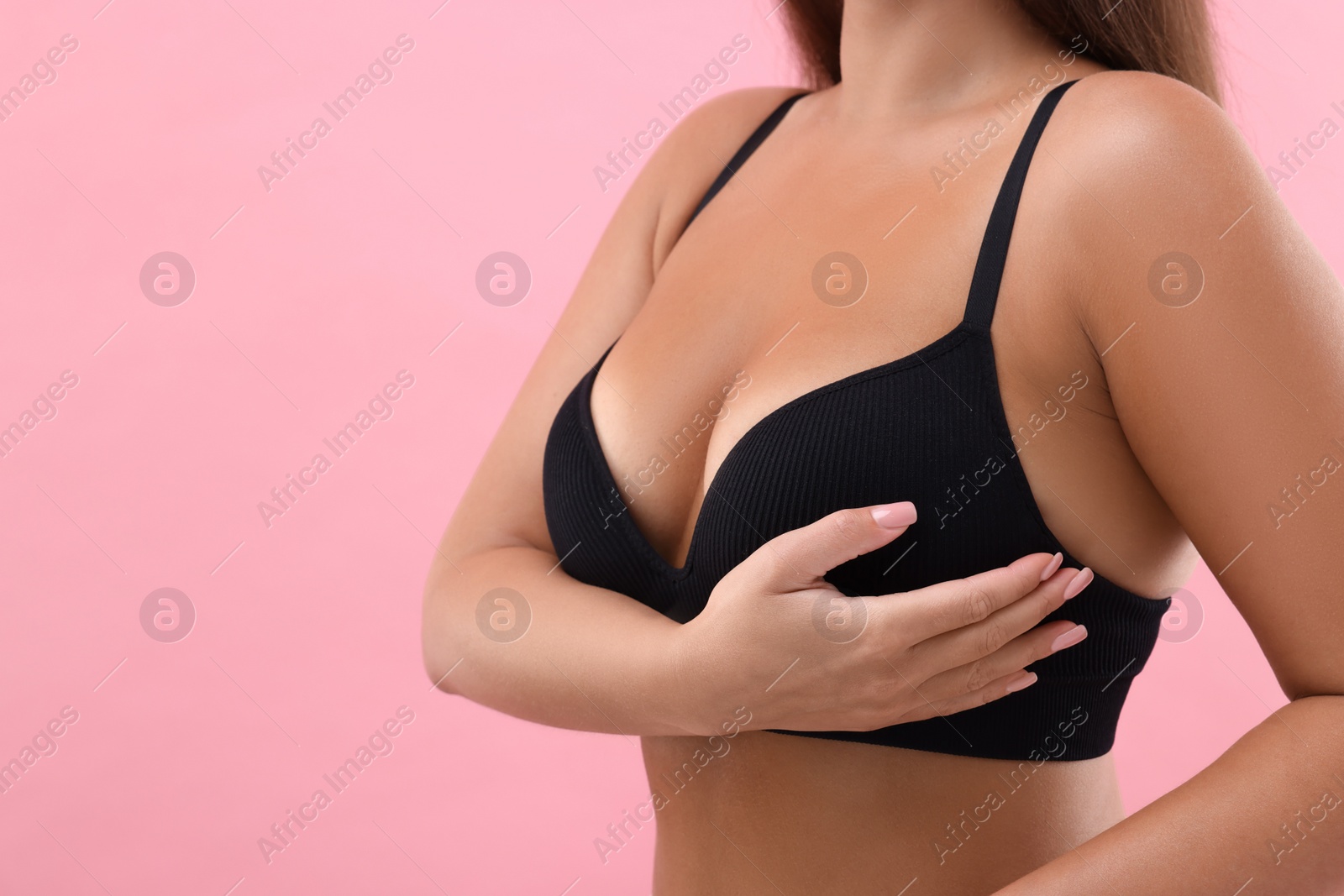 Photo of Woman with beautiful breast on pink background, closeup. Space for text