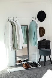 Photo of Rack with stylish clothes in modern dressing room