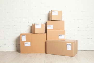 Photo of Stack of parcel boxes on floor against brick wall