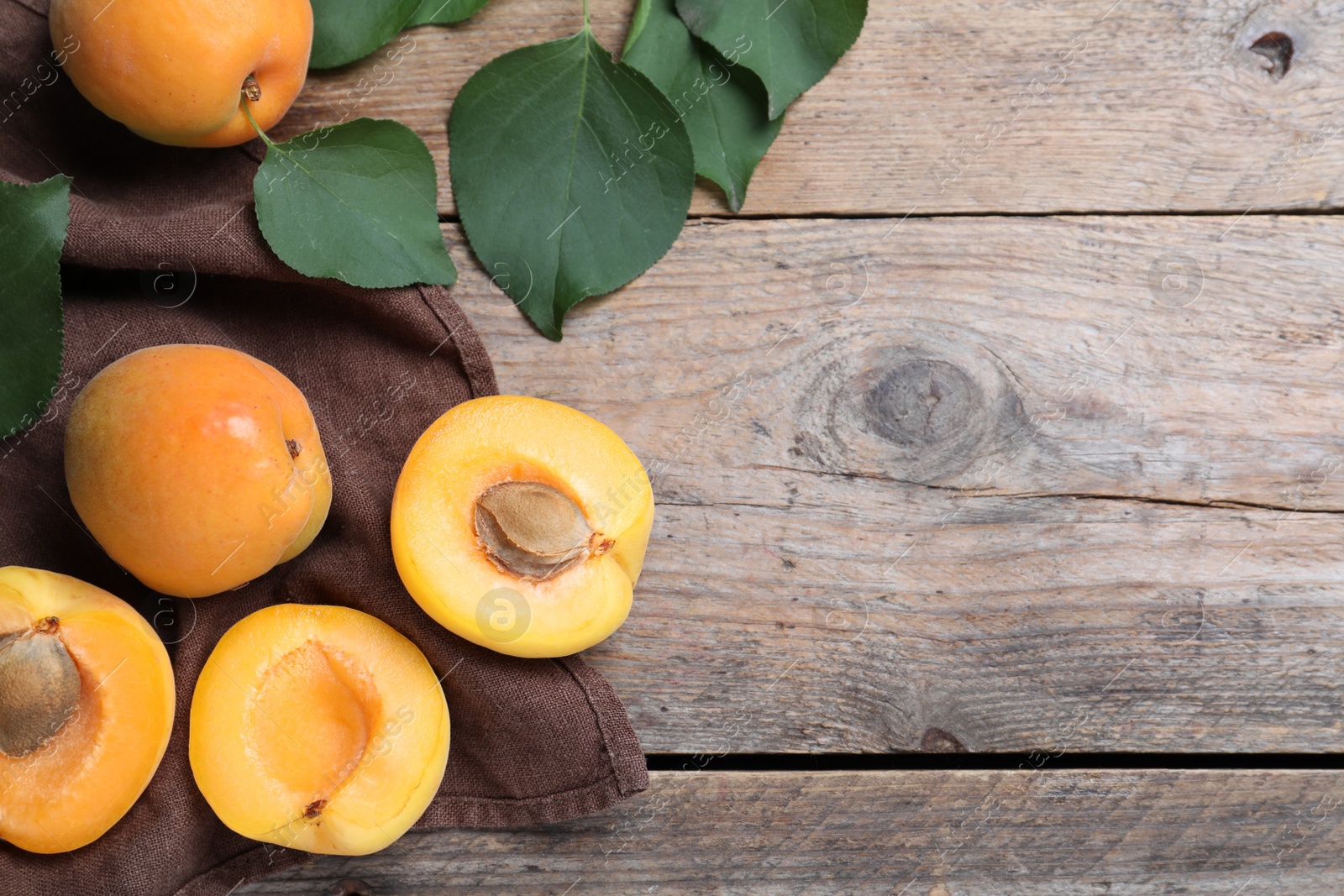 Photo of Delicious fresh ripe apricots on wooden table, flat lay. Space for text