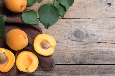 Delicious fresh ripe apricots on wooden table, flat lay. Space for text