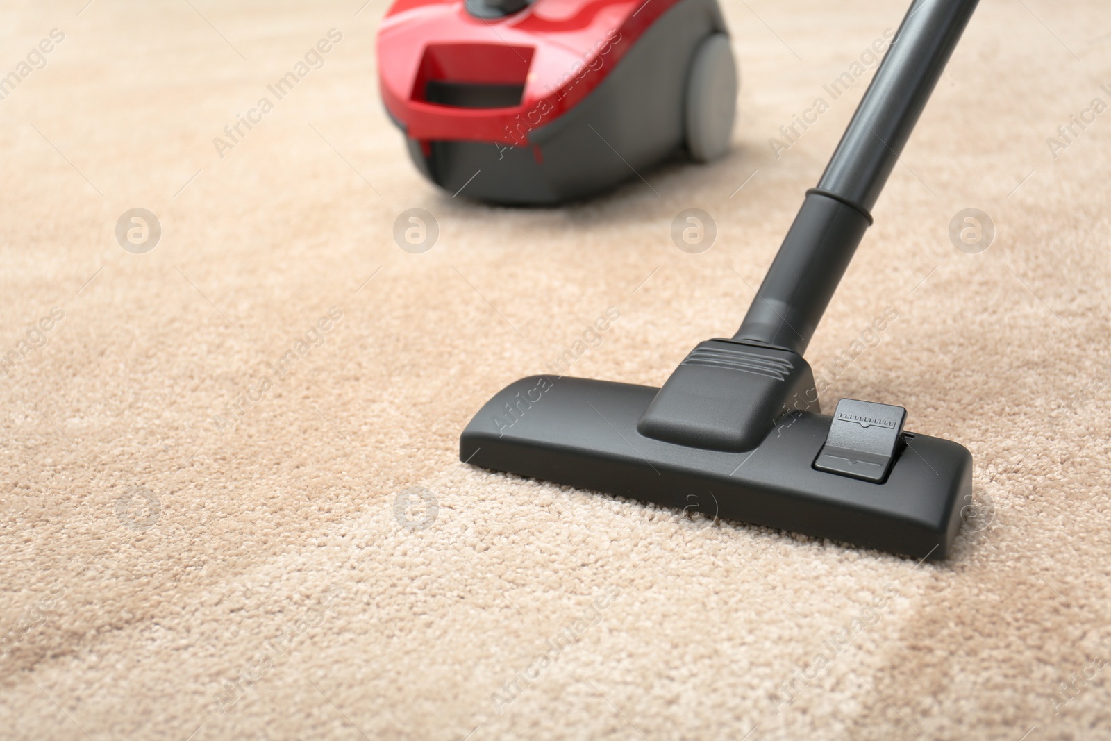 Image of Vacuuming dirty beige carpet. Clean area after using device, closeup