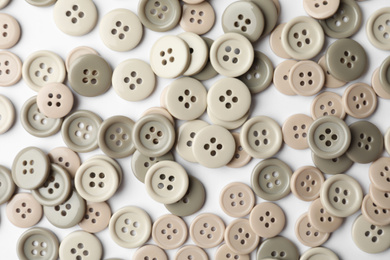 Many grey sewing buttons on white background, closeup