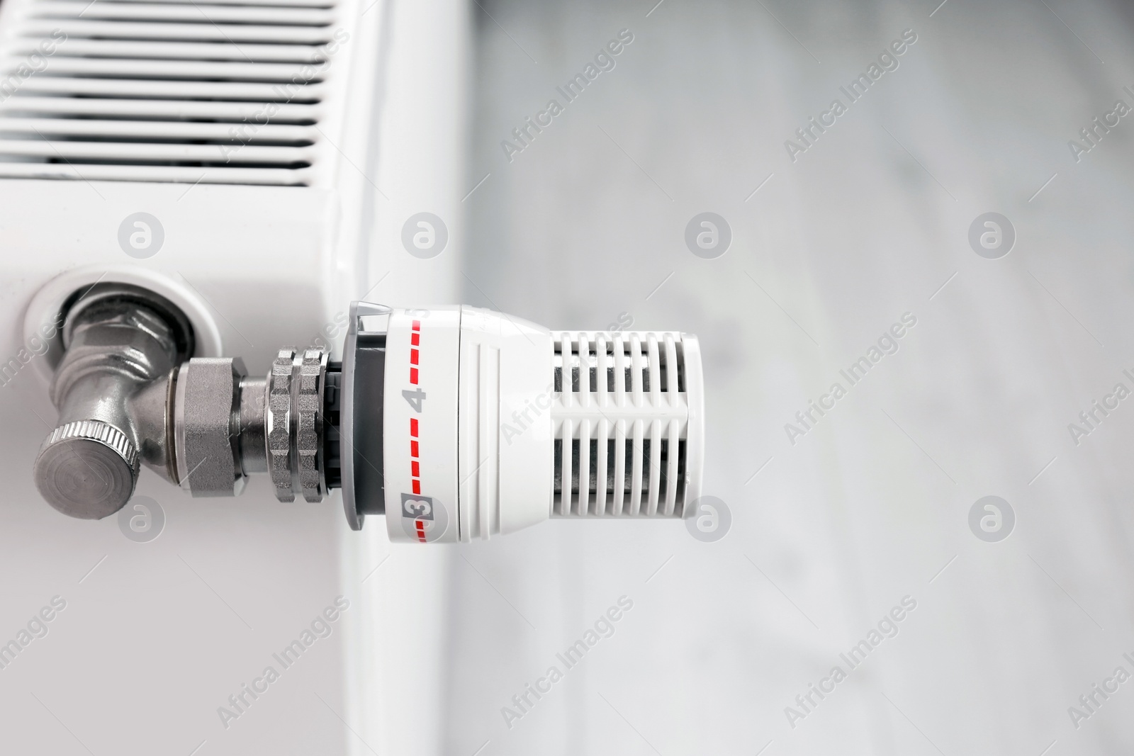 Photo of Heating radiator with manual thermostat, closeup view