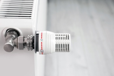Photo of Heating radiator with manual thermostat, closeup view
