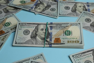 Money exchange. Dollar banknotes on light blue background, closeup