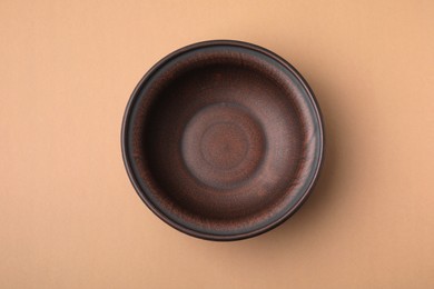 Ceramic bowl on beige background, top view