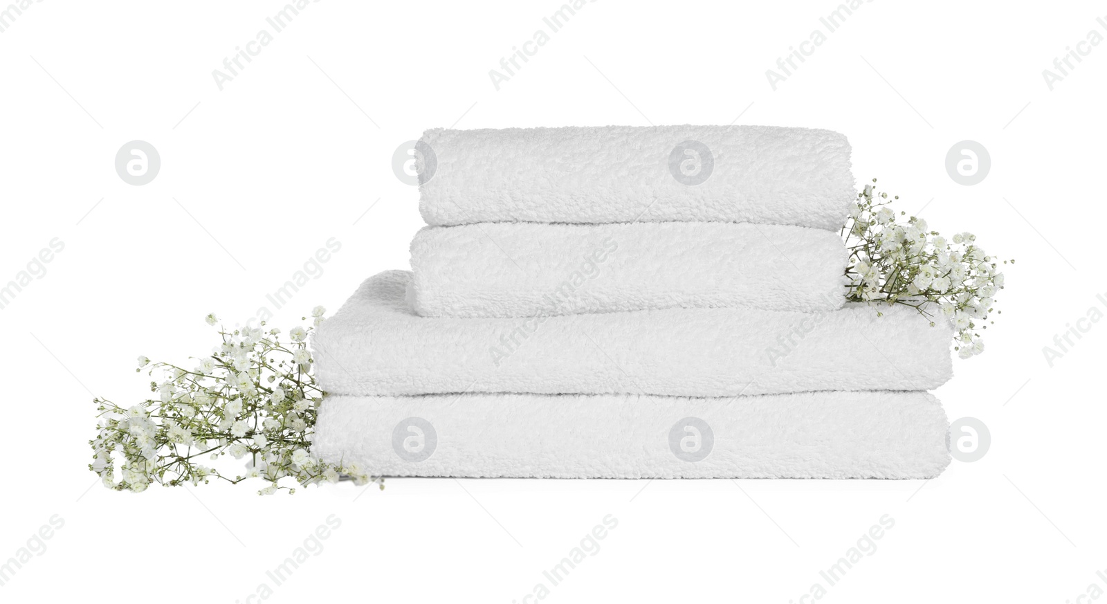 Photo of Stack of clean soft towels with flowers isolated on white