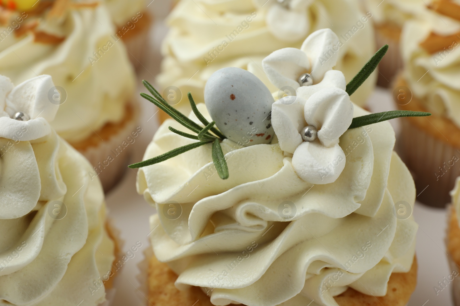 Photo of Tasty Easter cupcakes with vanilla cream, closeup