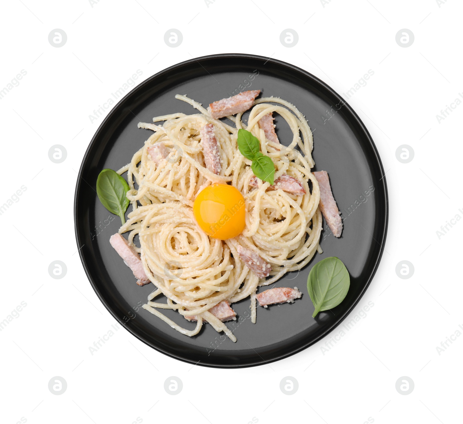 Photo of Plate of tasty pasta Carbonara with basil leaves and egg yolk isolated on white, top view