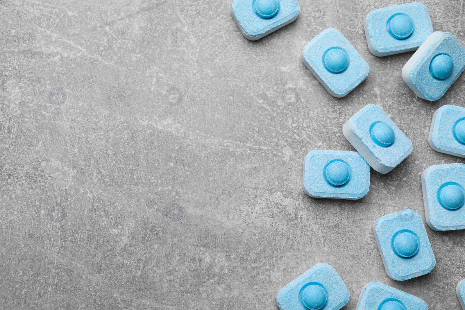 Photo of Water softener tablets on grey table, flat lay. Space for text