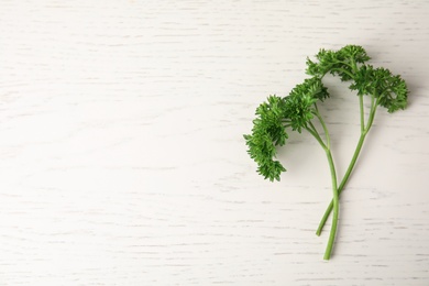 Photo of Fresh green parsley on white wooden table, flat lay. Space for text