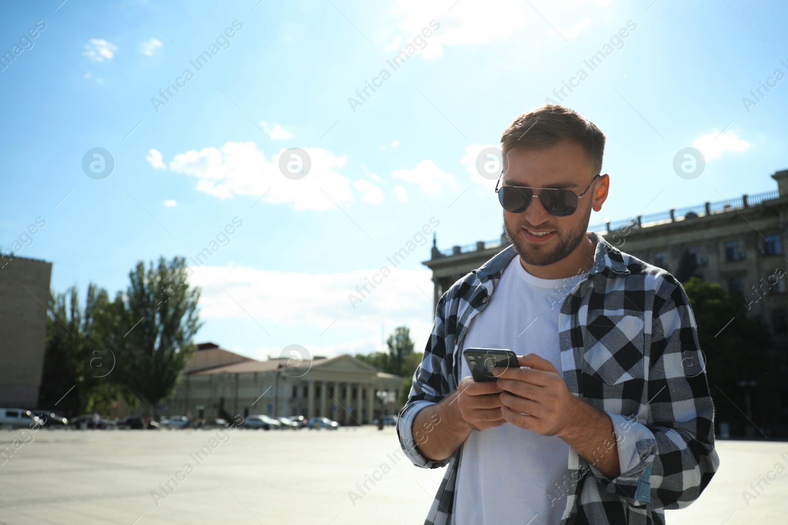 Photo of Young man with smartphone on city street