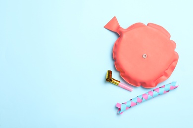 Photo of Whoopee cushion, party blower and chinese finger trap on light blue background, flat lay. Space for text