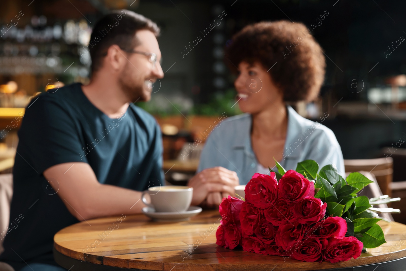 Photo of International dating. Happy couple spending time together in restaurant, selective focus