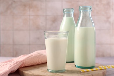 Glassware with tasty milk on table, space for text