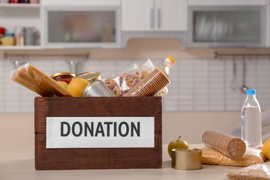 Photo of Donation box and different products on table indoors