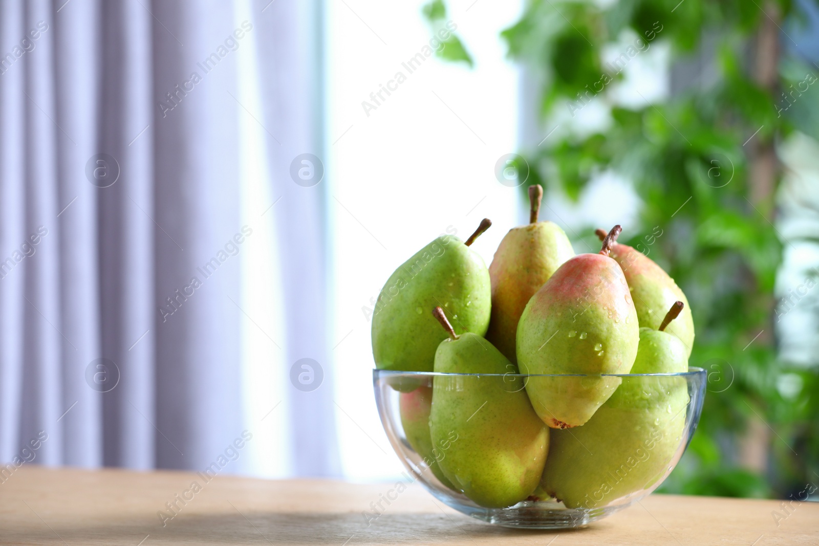 Photo of Fresh ripe pears on wooden table indoors. Space for text