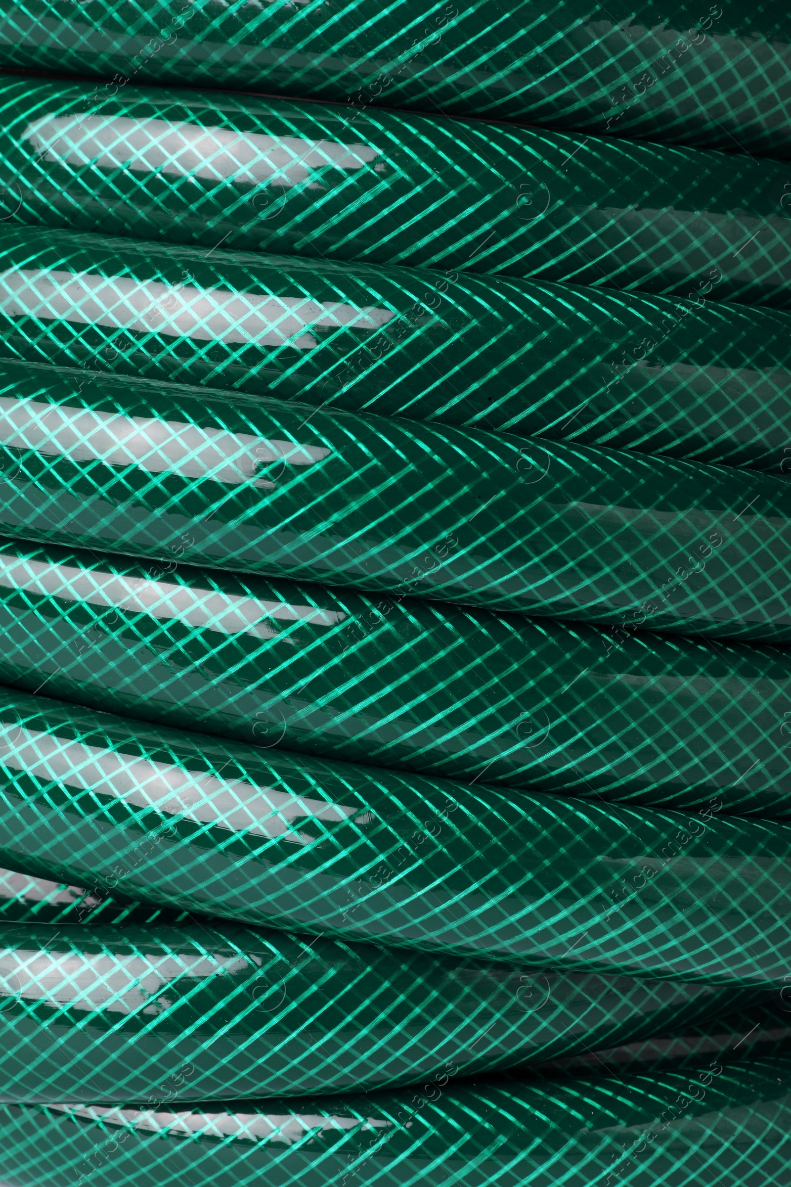 Photo of Green rubber watering hose as background, closeup