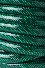 Green rubber watering hose as background, closeup