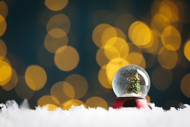 Photo of Beautiful snow globe with Christmas tree against blurred festive lights. Space for text