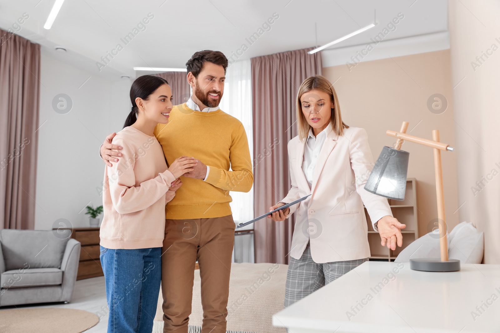 Photo of Real estate agent showing new apartment to couple