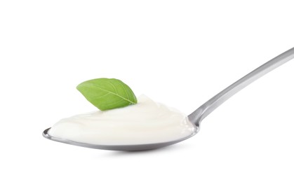 Photo of Delicious sour cream with basil in spoon isolated on white