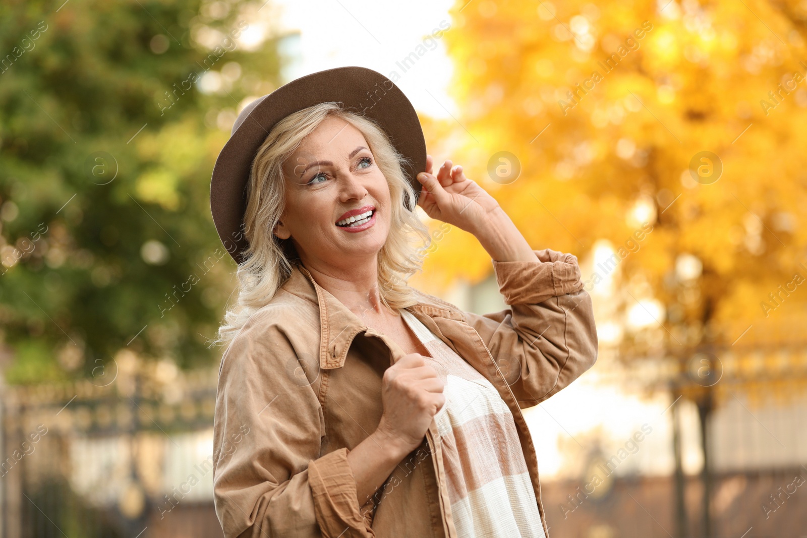 Photo of Portrait of happy mature woman with hat outdoors