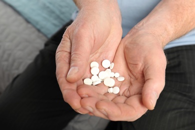 Photo of Senior man holding many pills in hands, closeup