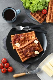 Photo of Tasty Belgian waffles served with bacon, butter and coffee on grey table, flat lay