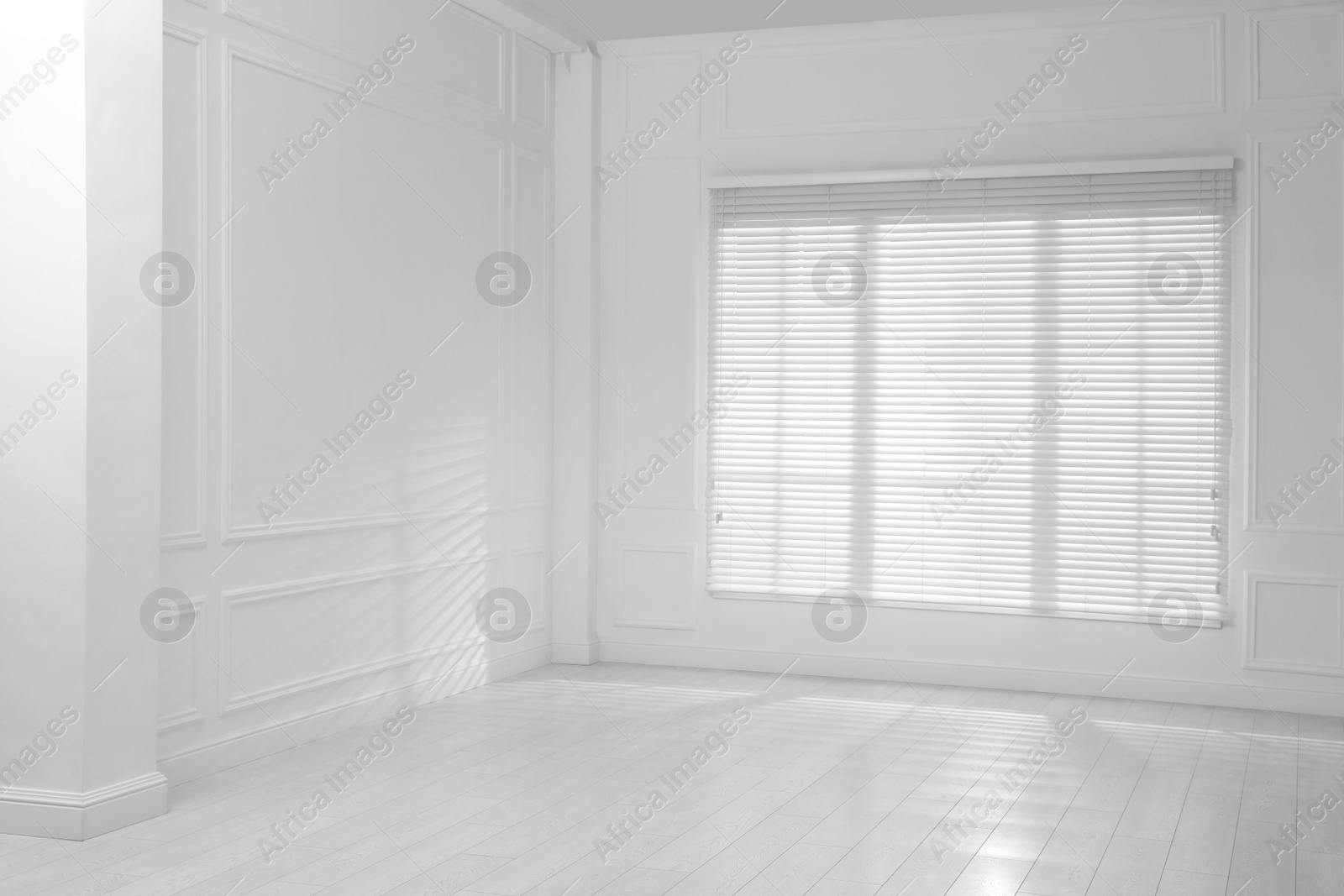 Photo of Empty room with white walls, large window and wooden floor