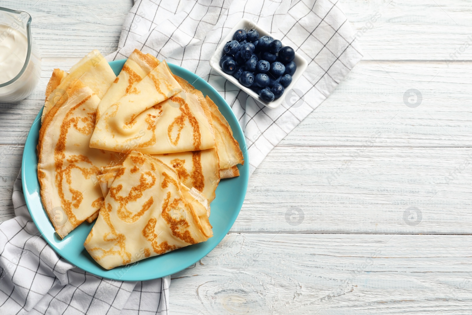 Photo of Plate with thin pancakes on wooden table