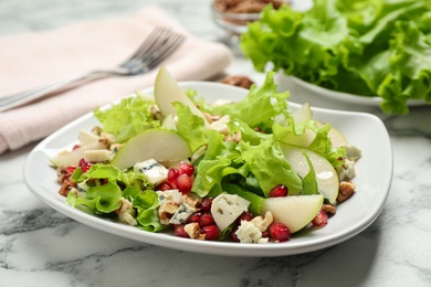 Photo of Tasty salad with pear slices on white marble table, closeup