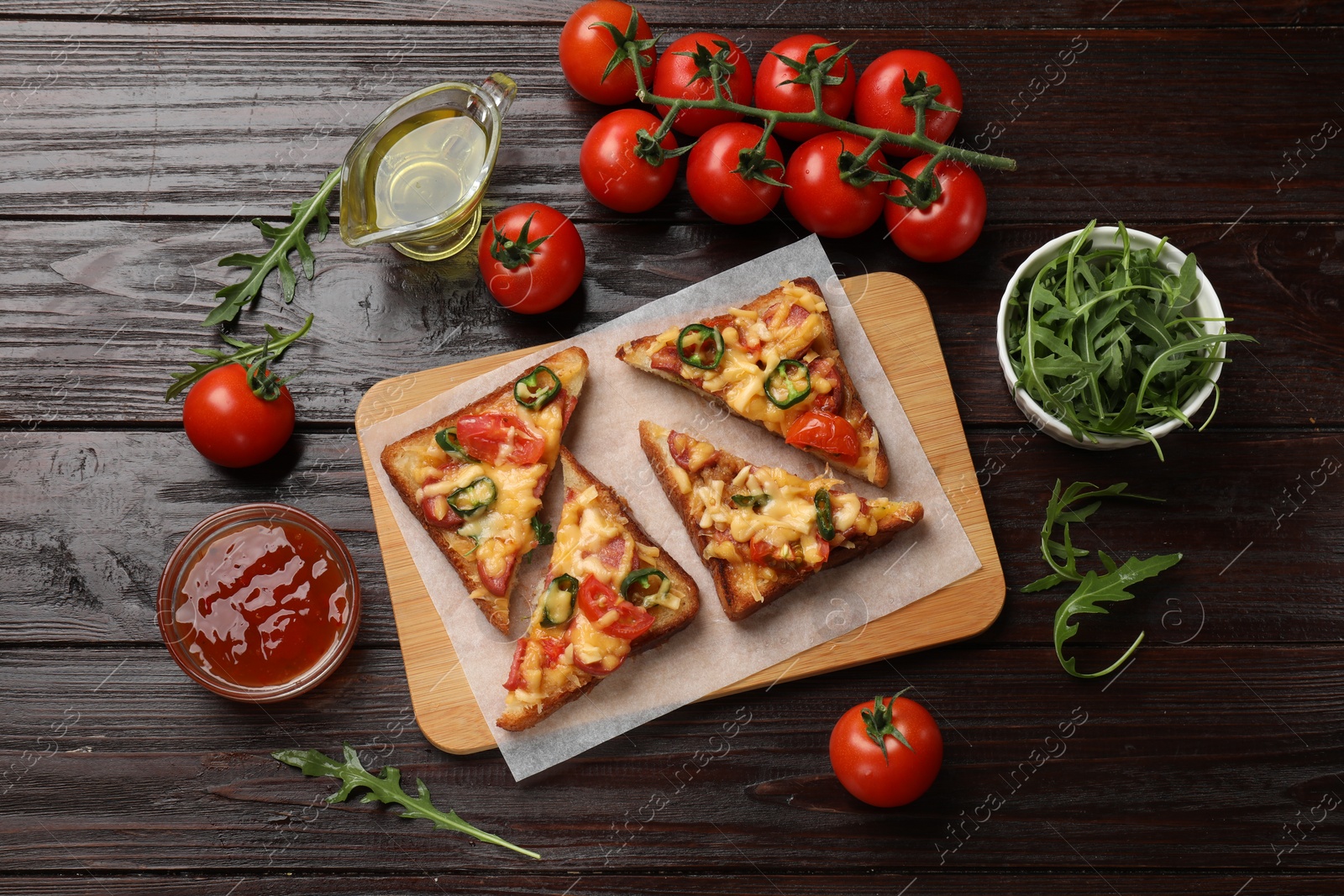 Photo of Tasty pizza toasts and ingredients on wooden table, flat lay