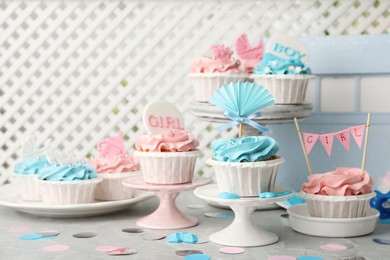 Photo of Delicious cupcakes with light blue and pink cream for baby shower on grey table