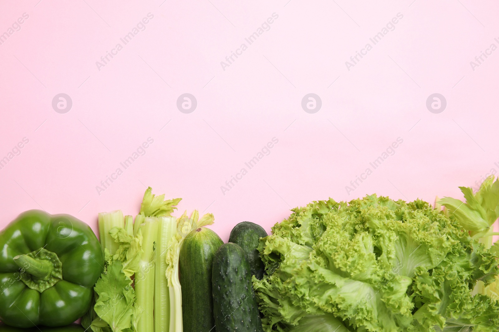 Photo of Flat lay composition with fresh salad ingredients on pink background, space for text