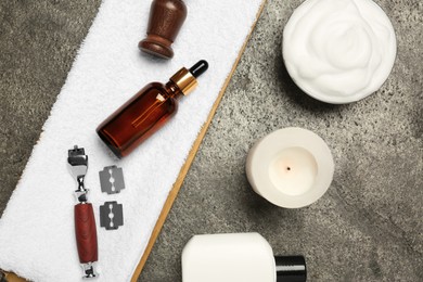 Photo of Different shaving accessories for men and candle on grey table, flat lay