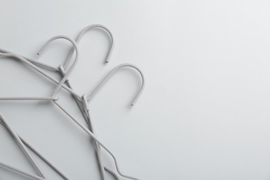Photo of Hangers on light gray background, top view. Space for text