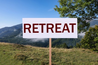 Image of Wooden sign with word Retreat and beautiful view of mountain landscape