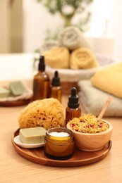 Photo of Dry flowers, loofah, soap bar, bottle of essential oil and jar with cream on wooden table indoors, space for text. Spa time