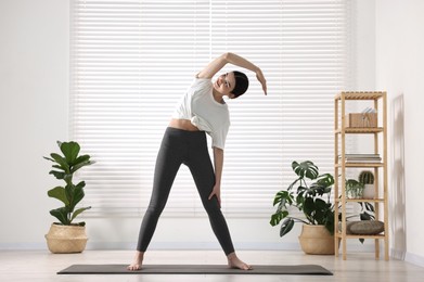 Girl stretching on mat in yoga studio. Janu Sirsasana pose variation